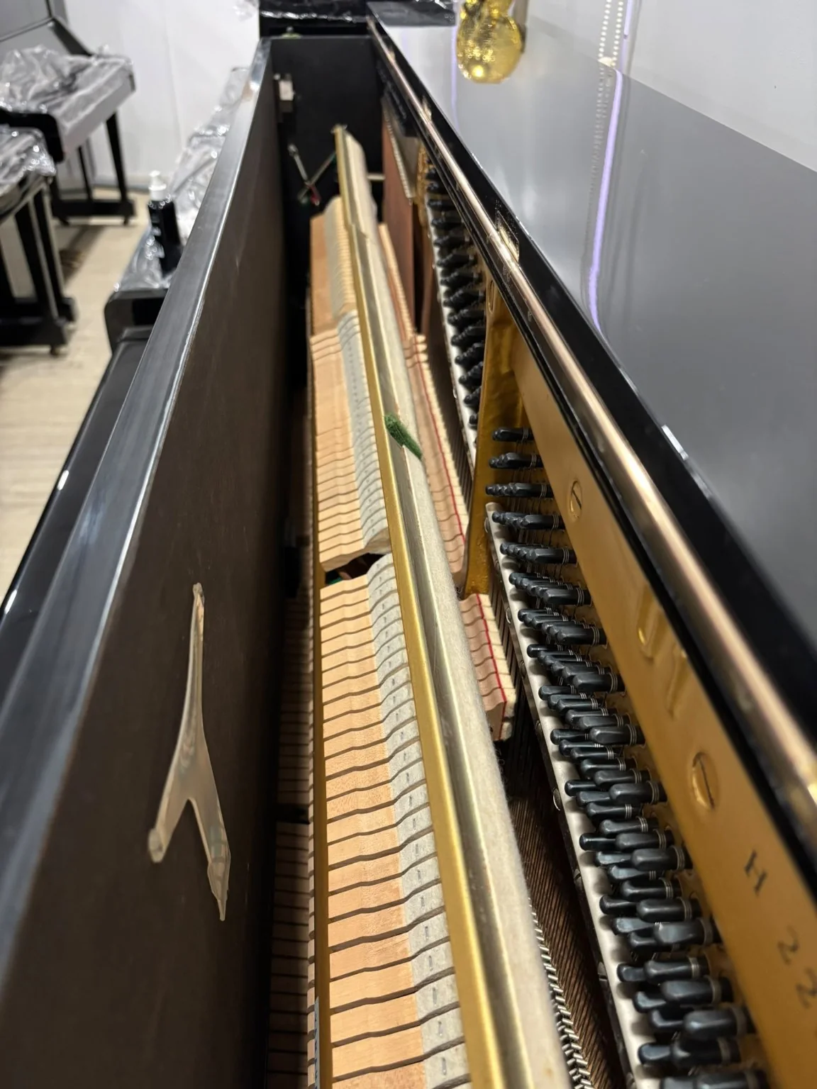 Interior view of Yamaha U1H upright piano action and tuning pins